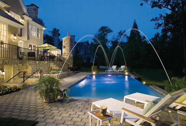 This geometric inground pool has premium features including a paver deck, deck jets, and a vanishing edge.