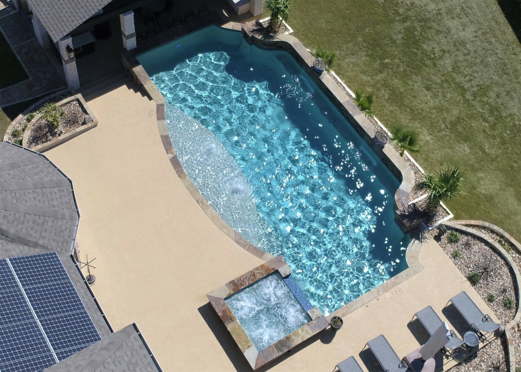 Modern pool in San Antonio, Texas, with raised spa, raised water features, and stone coping.