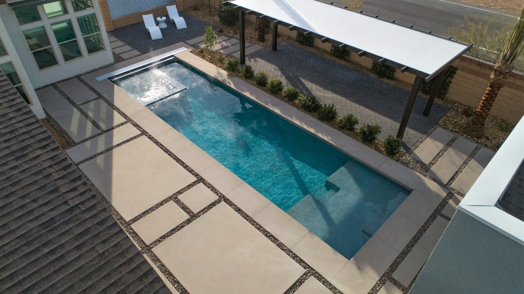 Geometric sport pool with automatic pool cover, spa, and shallow-end tanning ledge.