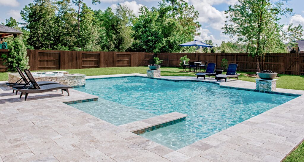 Backyard pool with lounge chairs and patio furniture.